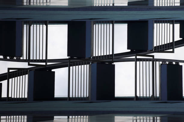 Digitally rendered fragment of modern / futuristic industrial architecture vista cercana de la parte inferior de industrial o fragmento con la escalera metálica de edificio de oficinas. procesa digitalmente arquitectura moderna fragmento despliegue hacia el cielo. antecedentes sobre el tema de negocios o de tecnología.