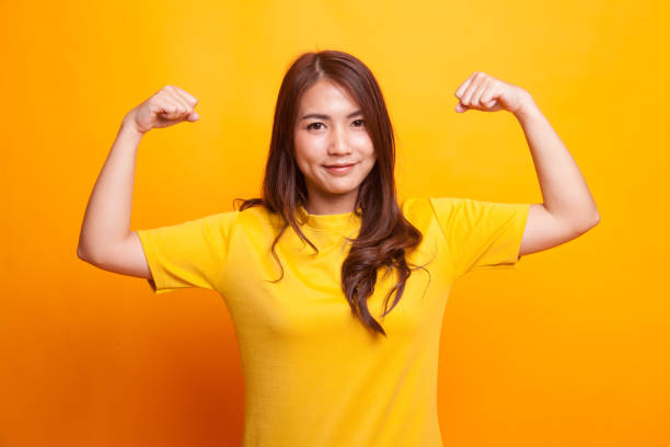 istock Beautiful young Asian woman flex bicep. 926155546