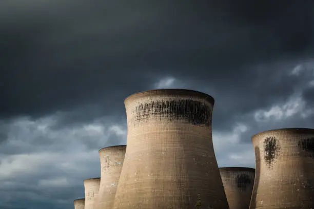 Landscape image of a power stations cooling towers with a moody overcast sky