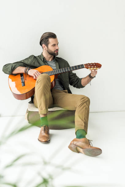 istock handsome man tuning acoustic guitar 926159232