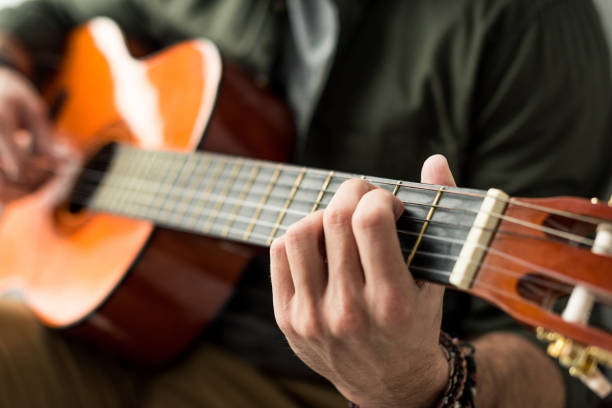 istock cropped image of man playing chord on acoustic guitar 926164148