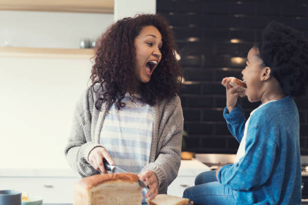 istock Mother imitating daughter eating bread at kitchen 926171476