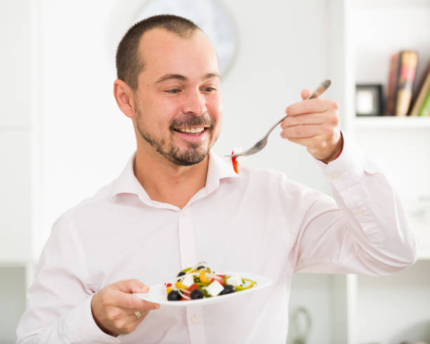 istock Smiling man looking at greek salad 926171886