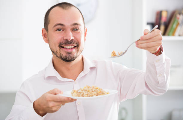 istock Positive young man eating porridge 926171916