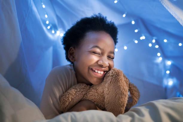 istock Happy girl embracing toy in tent 926172000