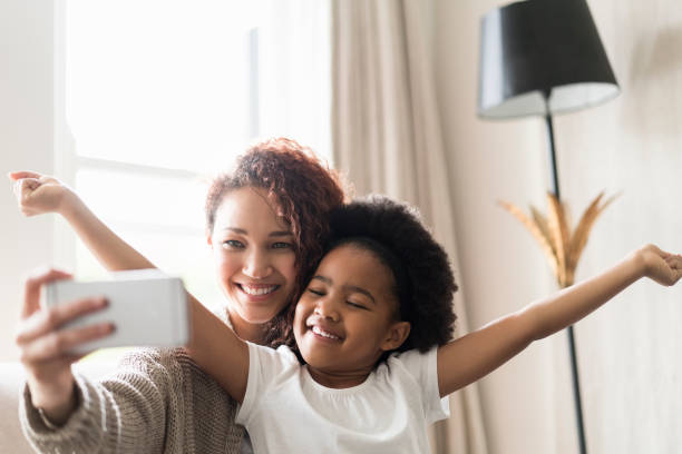istock Smiling mother and daughter taking selfie at home 926172054