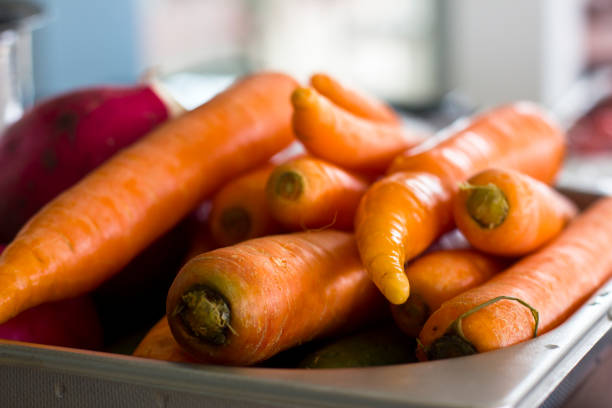 Fresh unclean whole carrots close-up. Selective focus