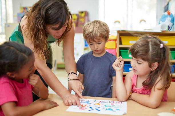 istock Teacher teaching students at desk in classroom 926172590
