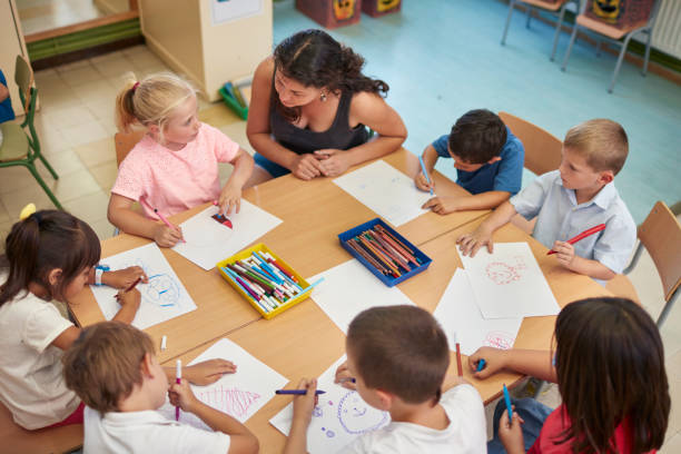 istock High angle view of teacher and students at desk 926172604