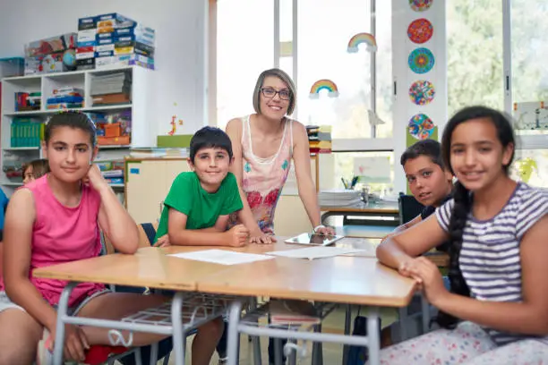 Photo of Portrait of smiling teacher and students in class