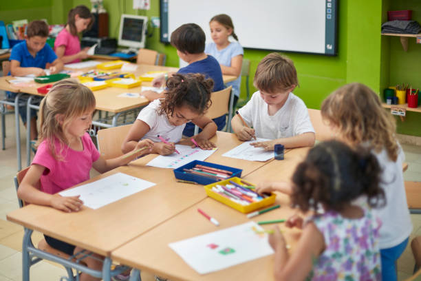 istock Schoolboys and schoolgirls drawing in classroom 926172684