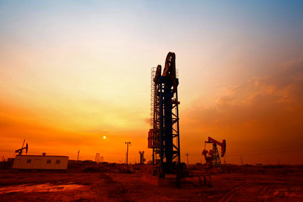 tempo do sol da bomba de óleo, equipamentos de indústria de petróleo - oil pumping unit at sunset time - fotografias e filmes do acervo