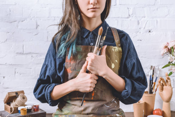 istock cropped image of female artist holding brushes 926178652