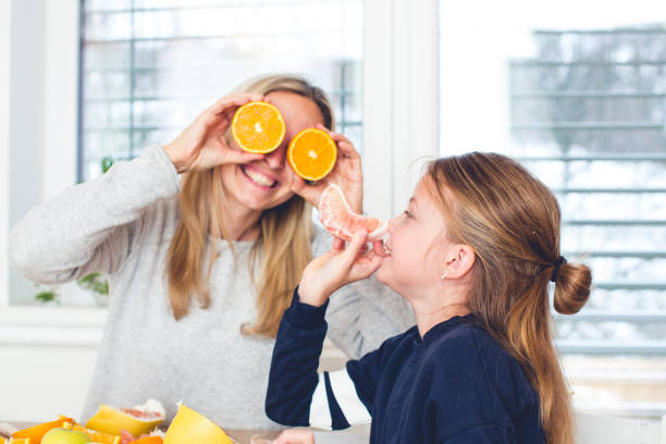 istock beautiful mother and daughter have fun while preparing fruit 926189458