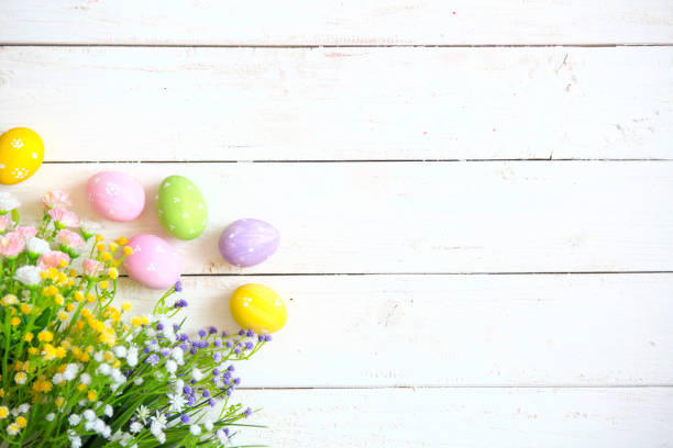 istock Easter eggs with flowers on white old wooden background 926189954