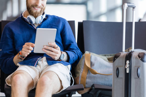 istock Young bearded man using digital tablet in airport lounge 926190156