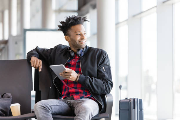 istock Young african using digital tablet in airport lounge 926196706