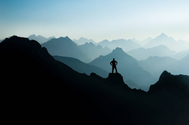 istock Spectacular mountain ranges silhouettes. Man reaching summit enjoying freedom. 926200780