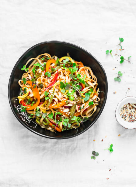 pad thai vegetarian vegetables udon noodles in a light background, top view. vegetarian food in asian style - thailand thai culture thai cuisine pad thai imagens e fotografias de stock