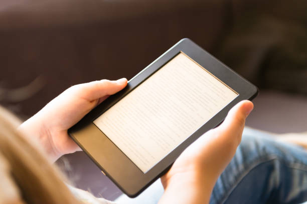 istock Girl is reading ebook while relaxing on the sofa 926219806
