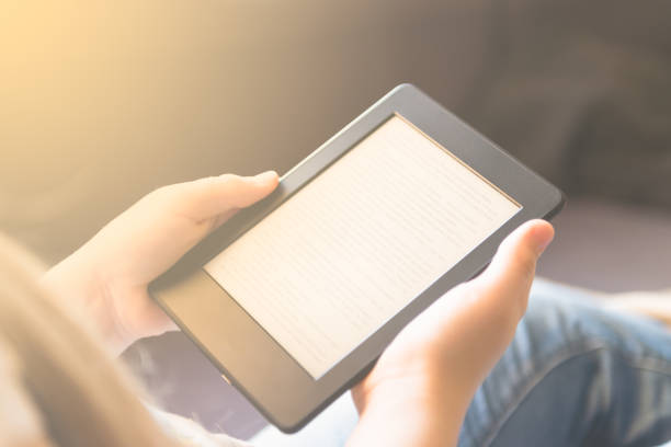 istock Girl is reading ebook while relaxing on the sofa 926219870