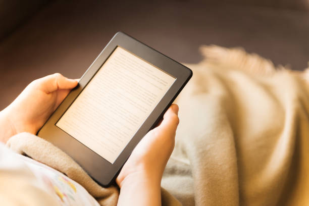 istock Girl is reading ebook while relaxing on the sofa 926220104