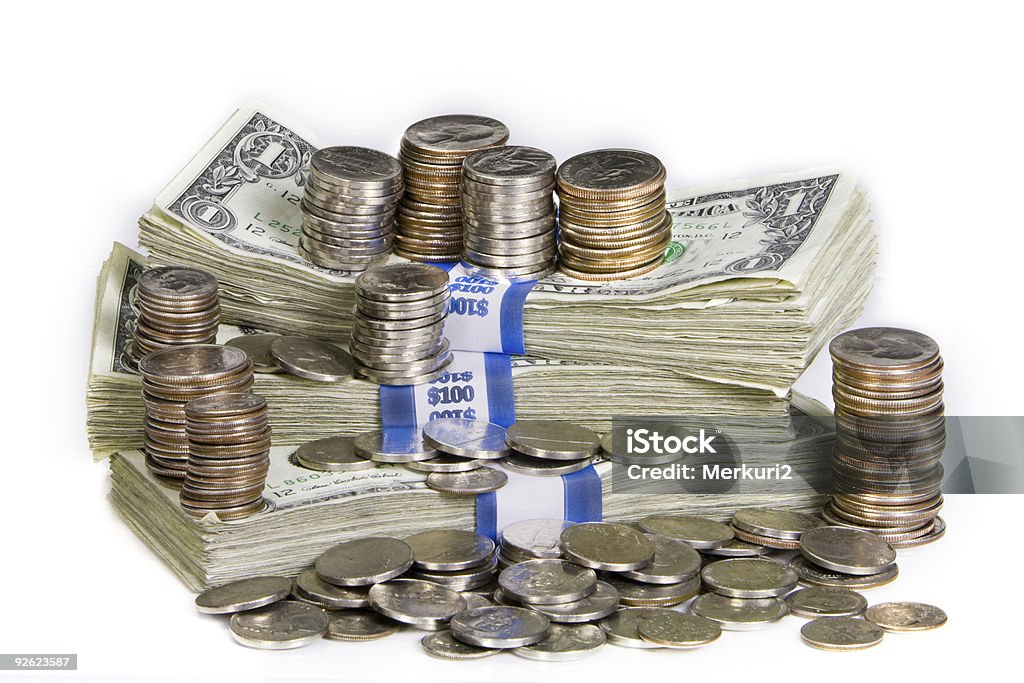 Stack of bank notes with piles of coins Coins and paper currency stacked against a white background. American One Hundred Dollar Bill Stock Photo