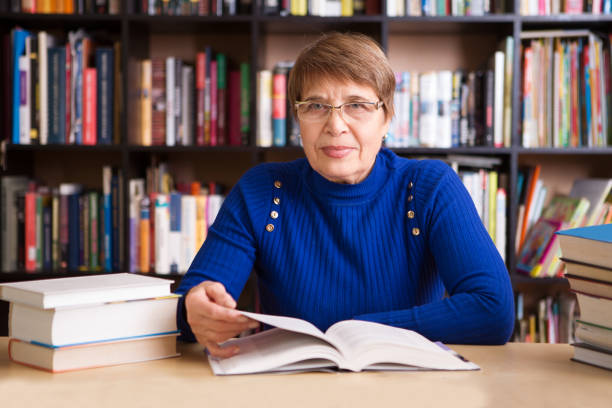 istock Happy senior woman  with books in library. 926238002