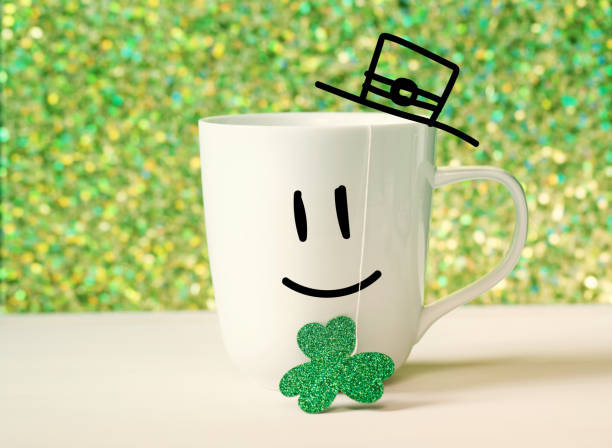 Green clover with happy face on white mug Saint Patricks Day green clover with happy face on white mug march month stock pictures, royalty-free photos & images