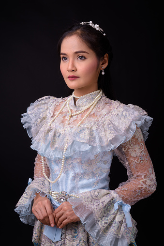 Portrait Of Thai Woman Wearing Traditional Clothes Against Black Background