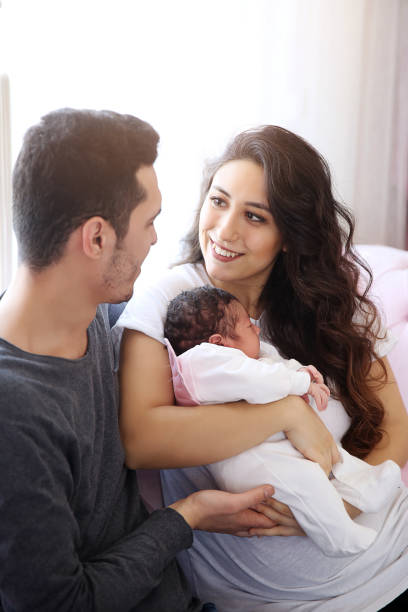 Father and mother holding newborn baby stock photo