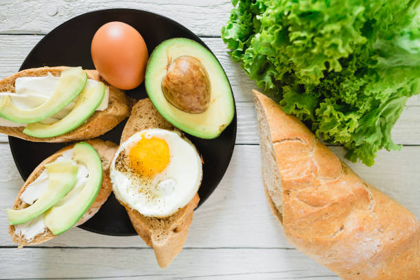 istock Sandwiches with avocado and egg on black plate on wooden table. Delicious natural breakfast 926267724