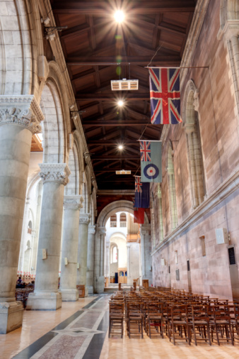 View of the interior of St. Anne's Cathedral, Belfast, Northern Ireland. It was built between 1889-1904. Shows the wooden roof and flags along the side, with the coloumns and arches on the opposite side. Three images with different exposures were taken and have been blended into one image cpturing detail in both the highlight  and shodow areas. Taken with Canon 50D