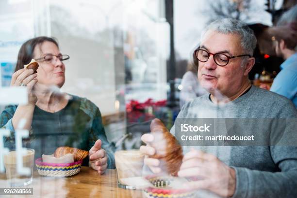 Senior Couple Eating In A Small Local Bakery Shop Stock Photo - Download Image Now - Eating, Bakery, Community