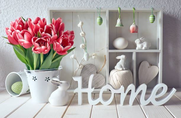istock Display cabinet with different objects and pink tulips, wooden word  