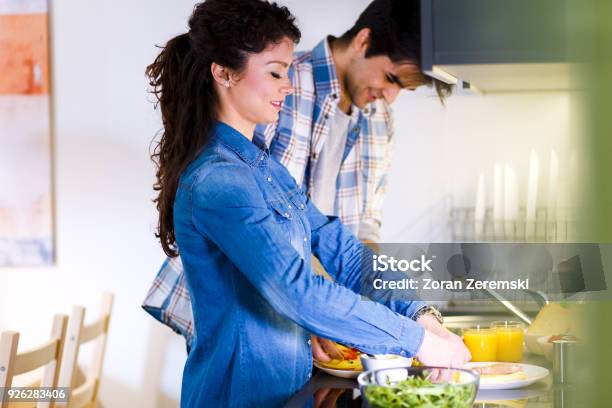 Young Couple Making Breakfast Early In The Morning In The Kitchen And Having A Good Time Stock Photo - Download Image Now