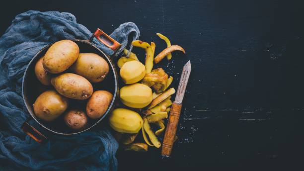 istock Raw potatoes on a black wooden background. Cooking. Free space for text. Top view. 926306792