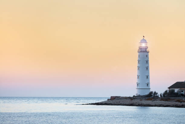 istock Lighthouse searchlight beam near ocean at sunset 926309070