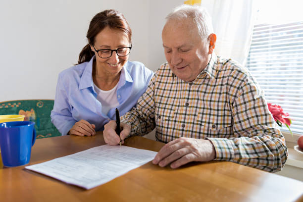 istock Caregiver and elderly man reading paperwork 926313042