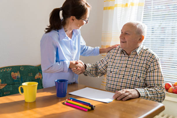 istock Home Caregiver talking with older man 926313058
