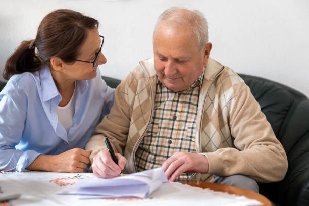 istock Caregiver and elderly man reading paperwork 926313192