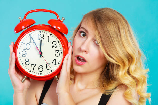 istock Shocked girl with alarm clock on blue. 926313380