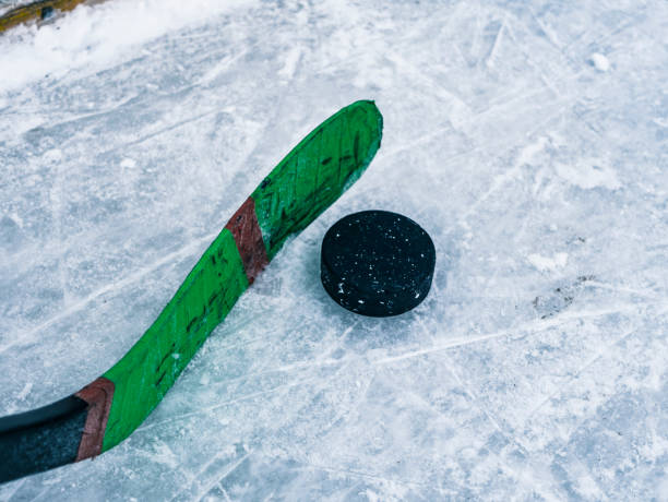 istock hockey puck and stick on the ice texture, copyspace and text 926316460