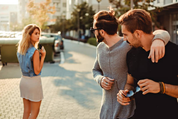 Male friends looking at the girl in the street stock photo