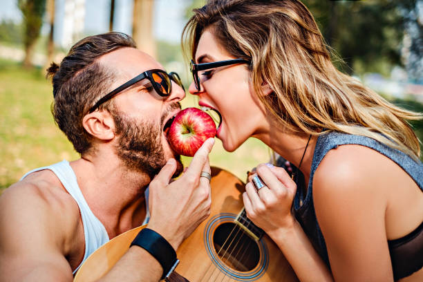 Couple eating apple together stock photo