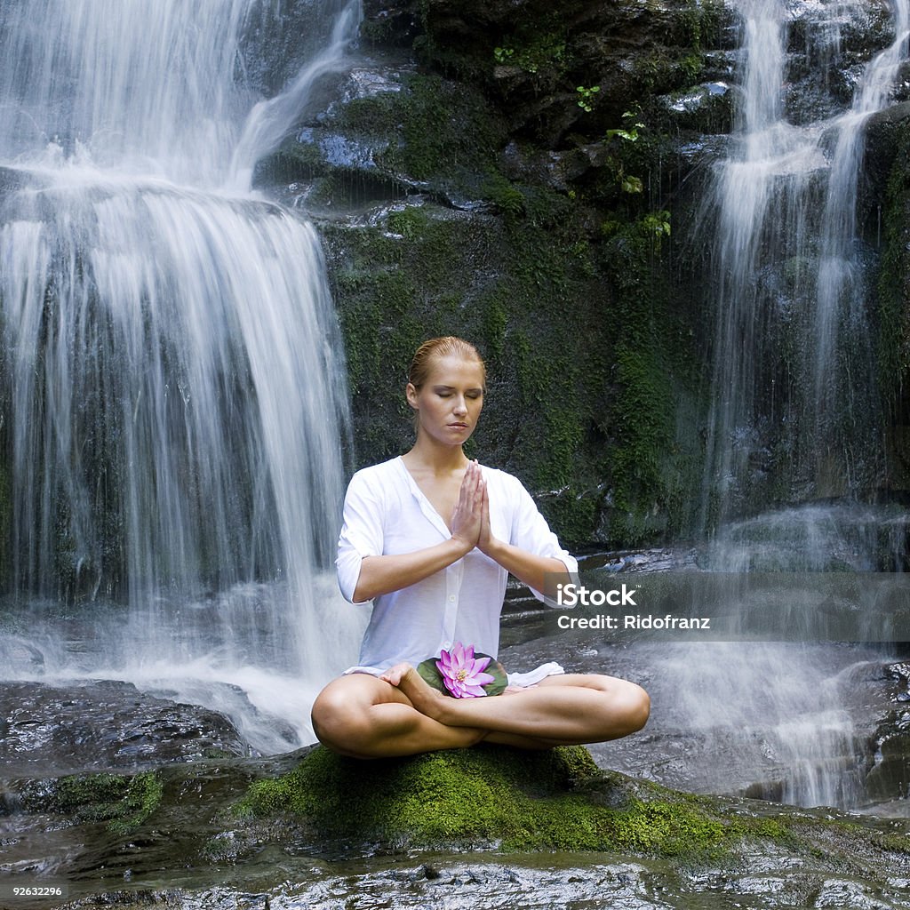 Young woman doing yoga near waterfalls  Adult Stock Photo