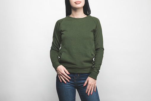 cropped shot of young woman in blank green sweatshirt on white