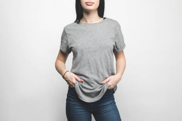 toma recortada de mujer joven con camiseta gris en blanco sobre blanco - gray shirt fotografías e imágenes de stock
