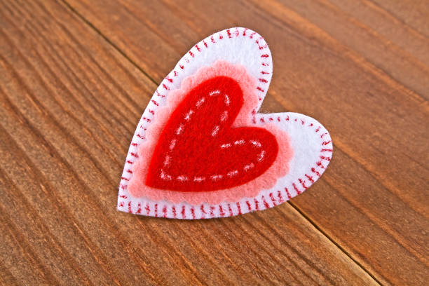 coloured felt hearts against a red background.