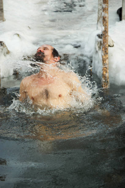 istock A middle-aged man is immersed in an ice hole. 926334780